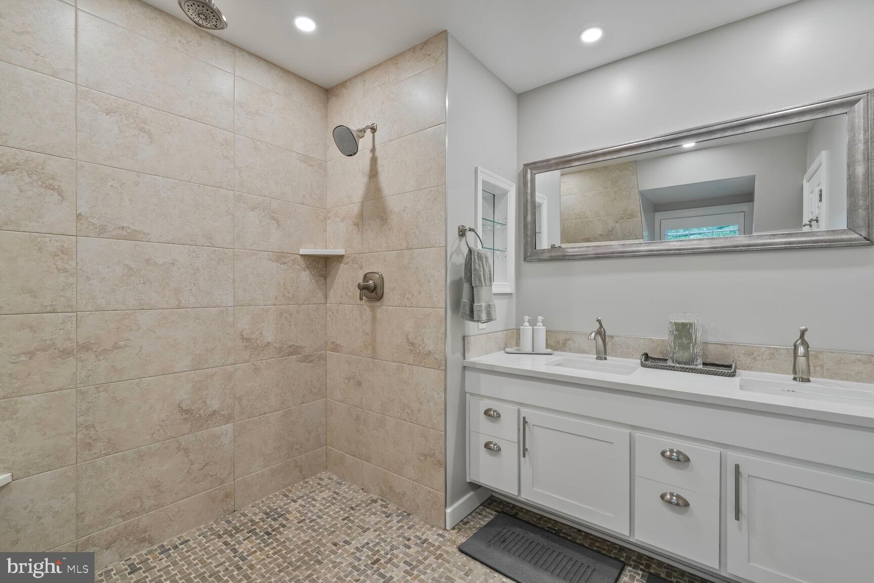 2327 North Glebe Road Arlington, VA 22207 - Photo 14 of 25 a bathroom with a double vanity sink a mirror and a shower