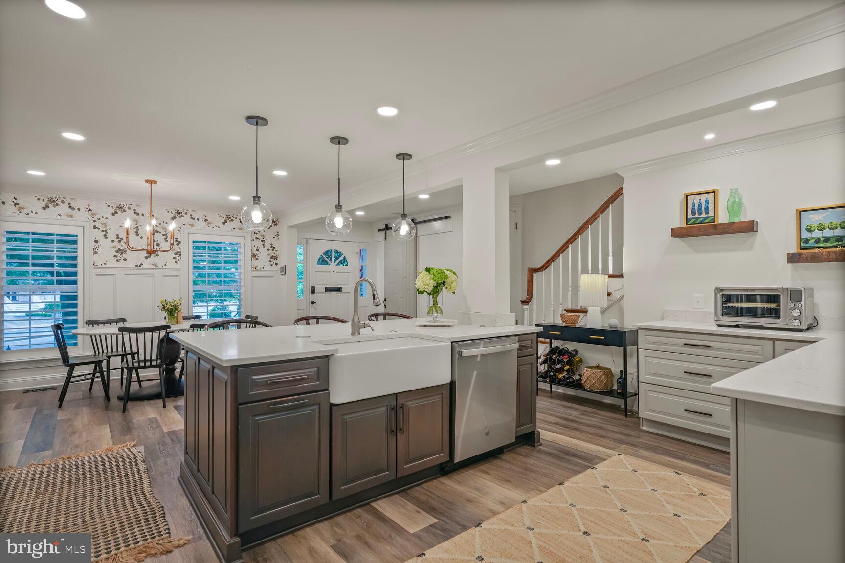 2327 North Glebe Road Arlington, VA 22207 - Photo 5 of 25 a large kitchen with kitchen island a sink a stove a dining table and chairs