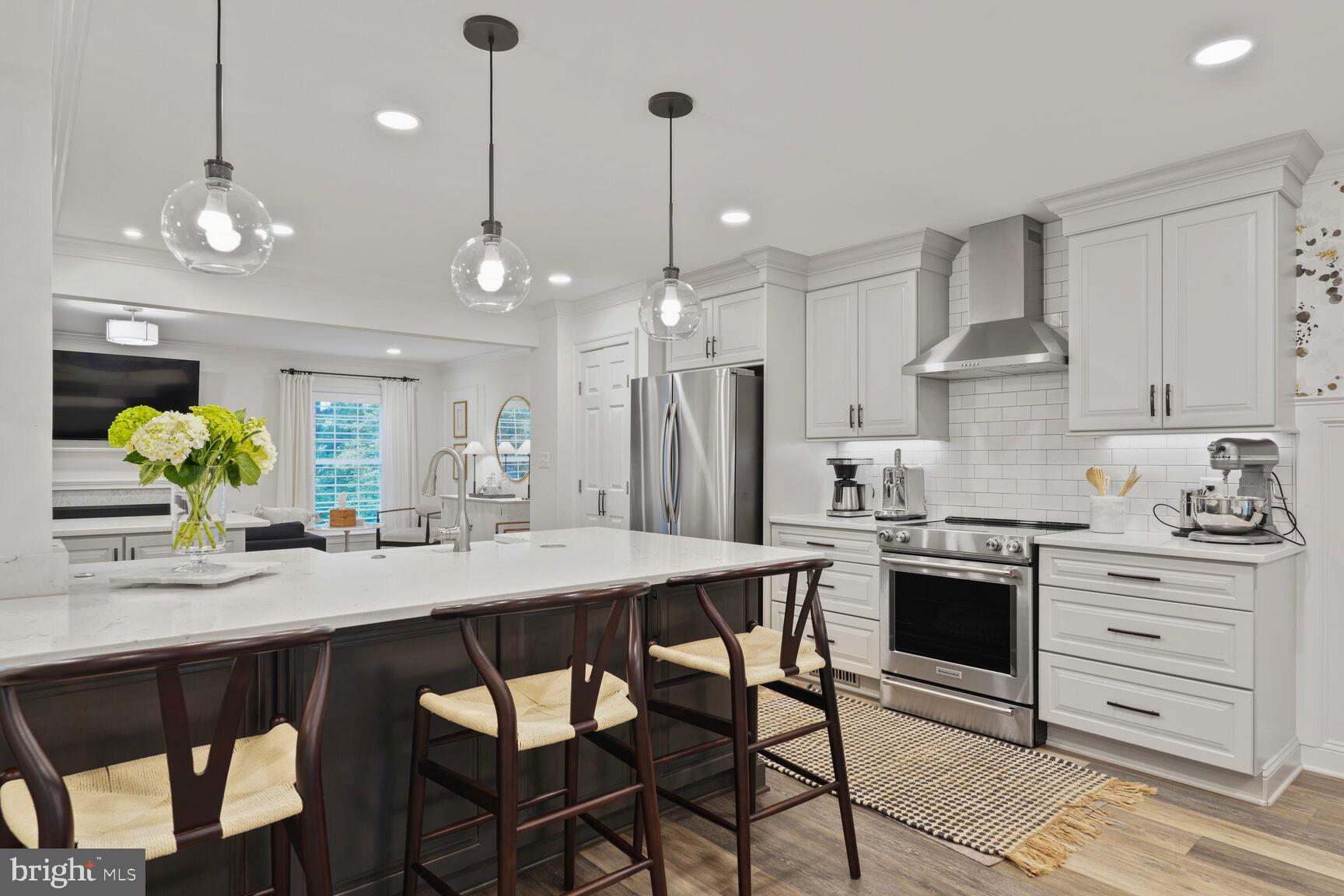 2327 North Glebe Road Arlington, VA 22207 - Photo 6 of 25 a kitchen with stainless steel appliances kitchen island granite countertop a dining table chairs and white cabinets