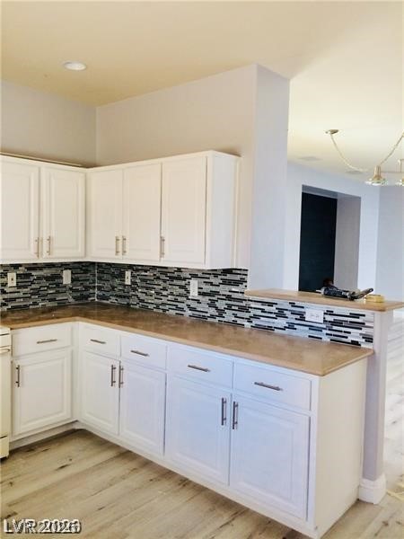 8897 Houston Ridge Avenue Las Vegas, NV 89178 - Photo 6 of 12 A well-lit kitchen showcasing ample cabinetry, contemporary tile backsplash, and durable countertops.