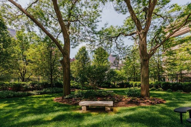 a view of a swimming pool with a bench and trees