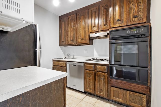 a kitchen with stainless steel appliances granite countertop a stove microwave and cabinets