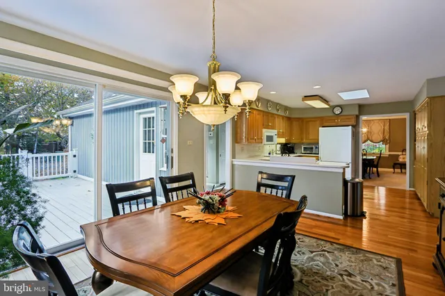 a dining room filled chandelier and wooden floor