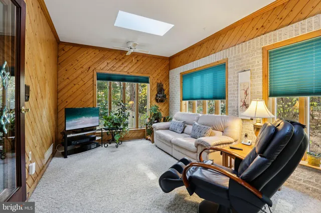 a living room with furniture a window and a flat screen tv