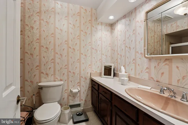 a bathroom with a granite countertop toilet sink and mirror