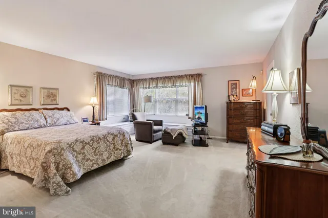 a large bedroom with a large bed and flat tv