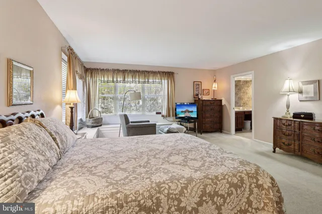 a bedroom with a bed a mirror and dresser