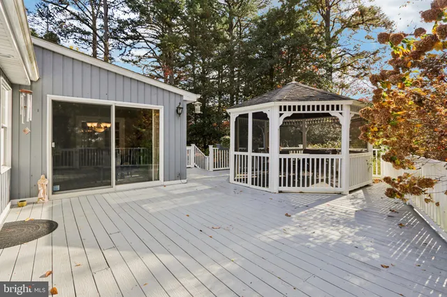 a view of a patio with table and chairs under an umbrella with a small yard