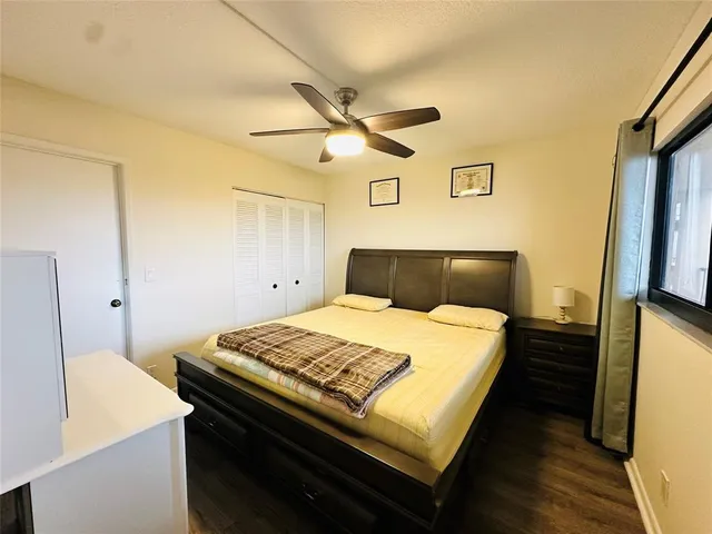 a bedroom with a bed and a flat tv screen on a dresser