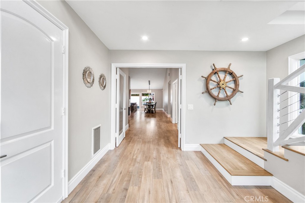 5522 Mossvale Circle Huntington Beach, CA 92649 - Photo 19 of 61 Bright connecting hallways lead to bedrooms while showcasing the striking glass entry and staircase.