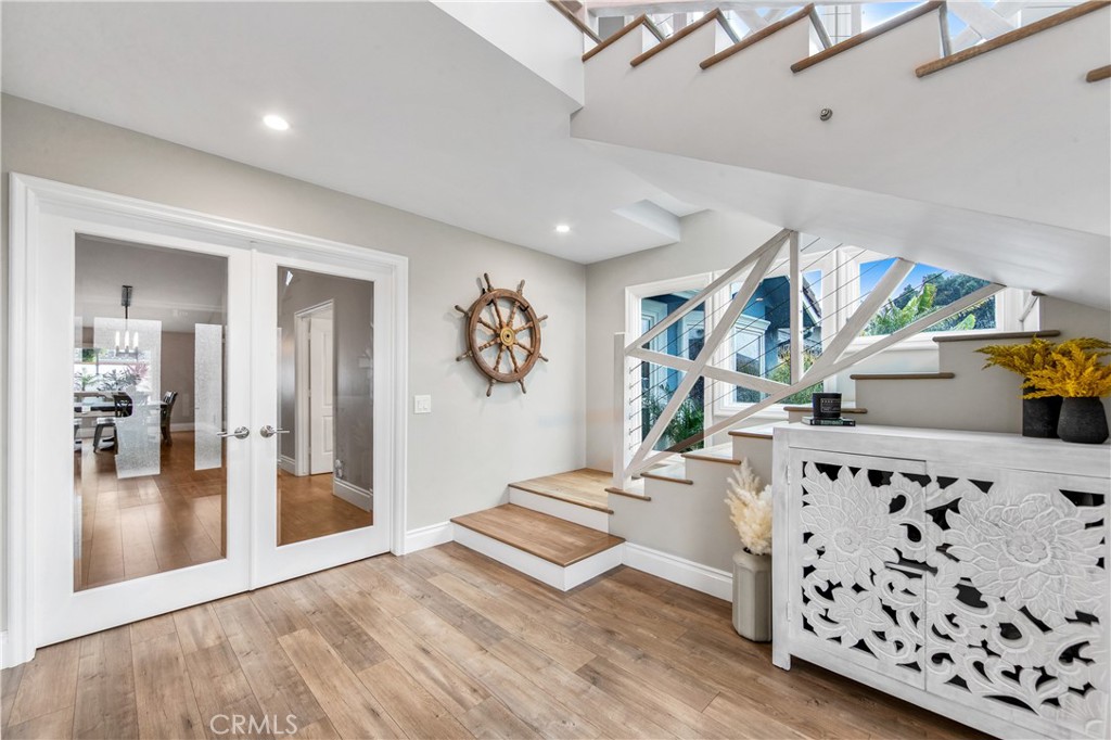 5522 Mossvale Circle Huntington Beach, CA 92649 - Photo 21 of 61 Bright connecting hallways lead to bedrooms while showcasing the striking glass entry and staircase.