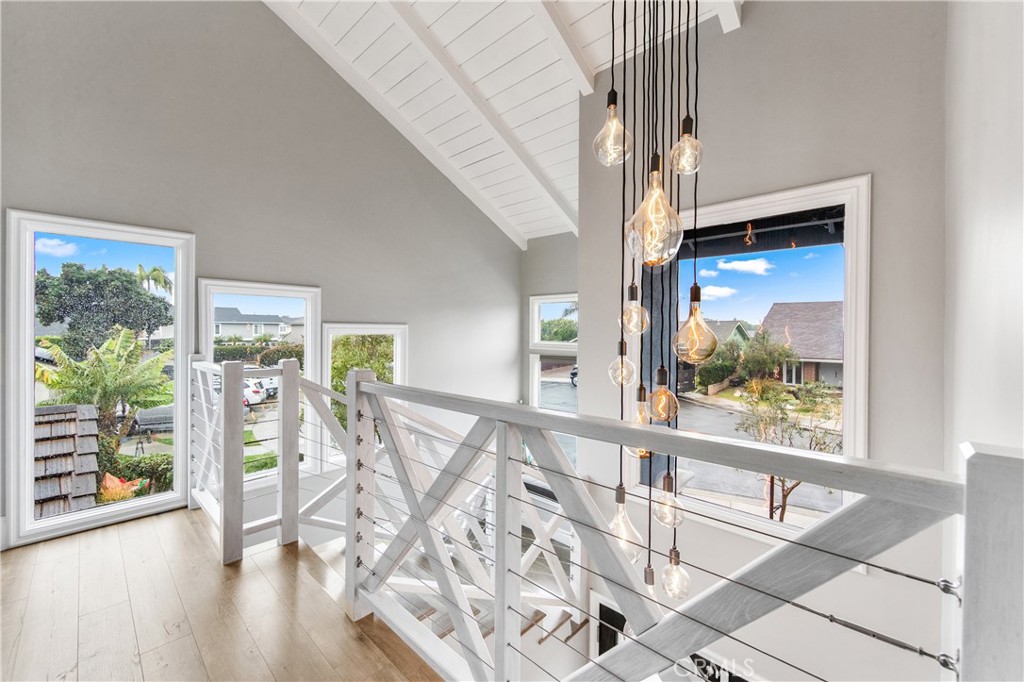 5522 Mossvale Circle Huntington Beach, CA 92649 - Photo 24 of 61 Sun-drenched custom staircase with nautical-inspired railings winds to a mezzanine retreat, complete with a cozy reading nook framed by two-story windows.