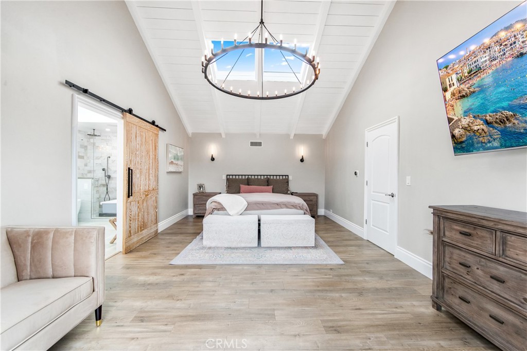 5522 Mossvale Circle Huntington Beach, CA 92649 - Photo 25 of 61 Grand primary suite with soaring ceilings, skylight, statement chandelier, Juliet balcony, and coastal breezes from the wetlands.