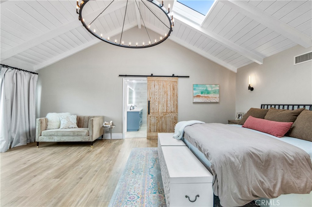 5522 Mossvale Circle Huntington Beach, CA 92649 - Photo 26 of 61 Grand primary suite with soaring ceilings, skylight, statement chandelier, Juliet balcony, and coastal breezes from the wetlands.
