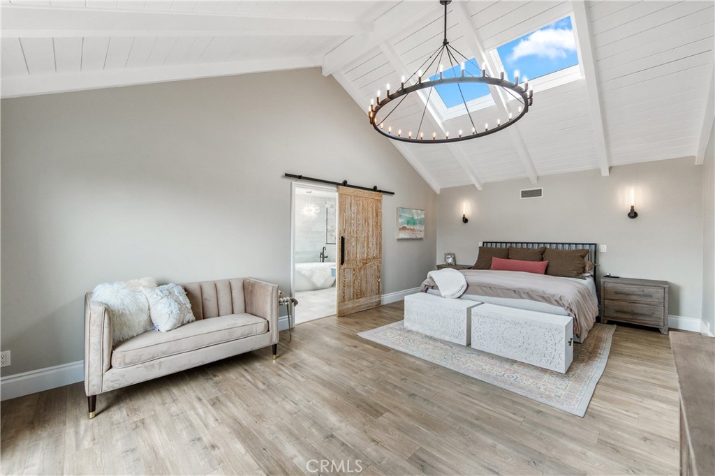 5522 Mossvale Circle Huntington Beach, CA 92649 - Photo 27 of 61 Grand primary suite with soaring ceilings, skylight, statement chandelier, Juliet balcony, and coastal breezes from the wetlands.