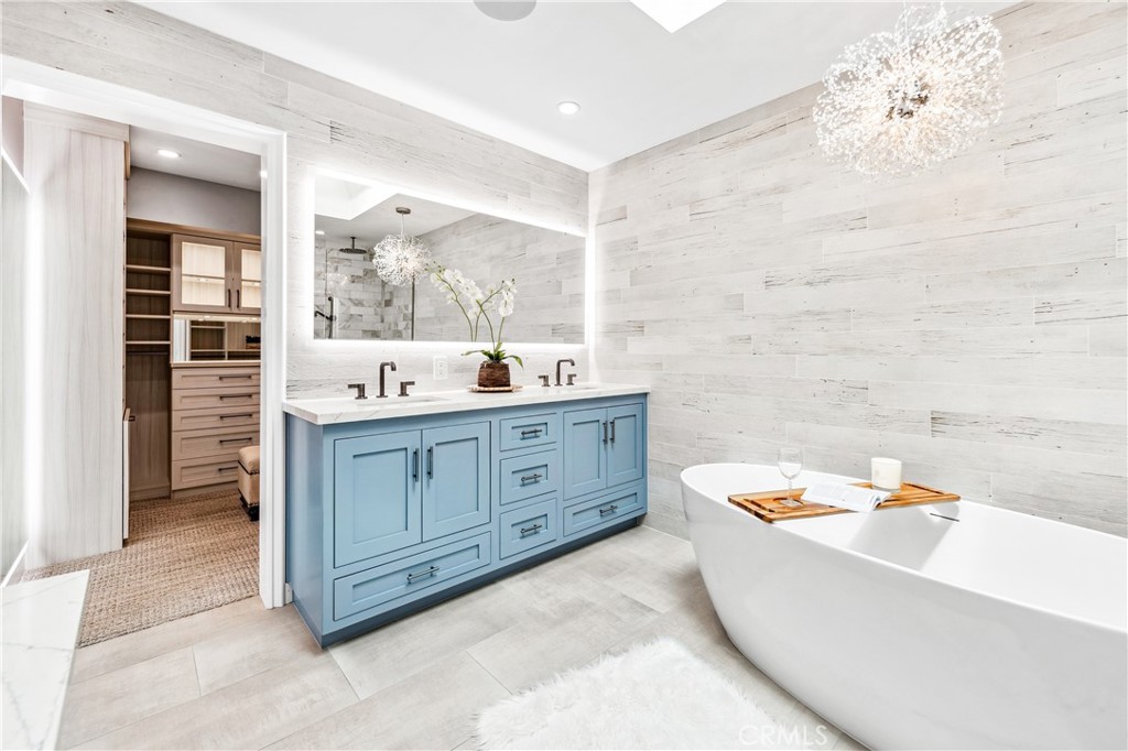 5522 Mossvale Circle Huntington Beach, CA 92649 - Photo 32 of 61 Luxurious spa bath featuring a sculptural soaking tub, marble shower, illuminated vanities, designer lighting, and custom closet.
