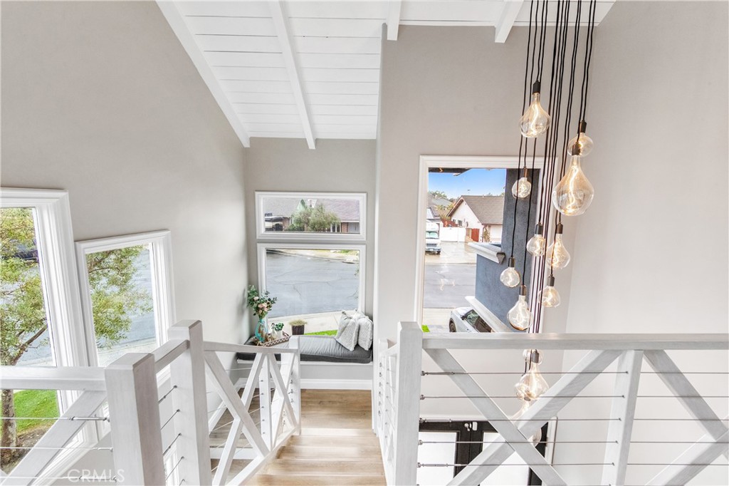 5522 Mossvale Circle Huntington Beach, CA 92649 - Photo 35 of 61 Sun-drenched custom staircase with nautical-inspired railings winds to a mezzanine retreat, complete with a cozy reading nook framed by two-story windows.