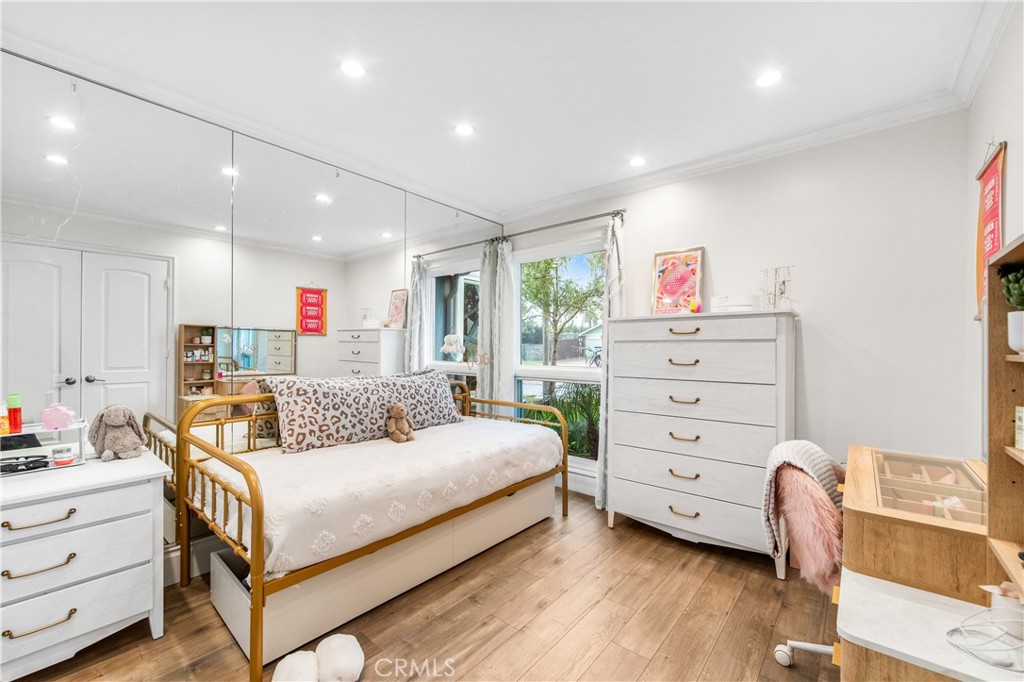 5522 Mossvale Circle Huntington Beach, CA 92649 - Photo 46 of 61 Light-filled main-floor bedroom with mirrored wall, garden-facing window, and clean modern finishes.