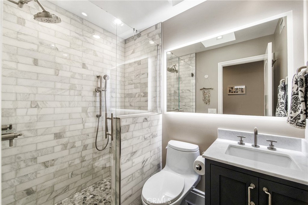 5522 Mossvale Circle Huntington Beach, CA 92649 - Photo 49 of 61 Bright designer bath with marble shower, dual heads, stacked stone accents, and elegant vanity.
