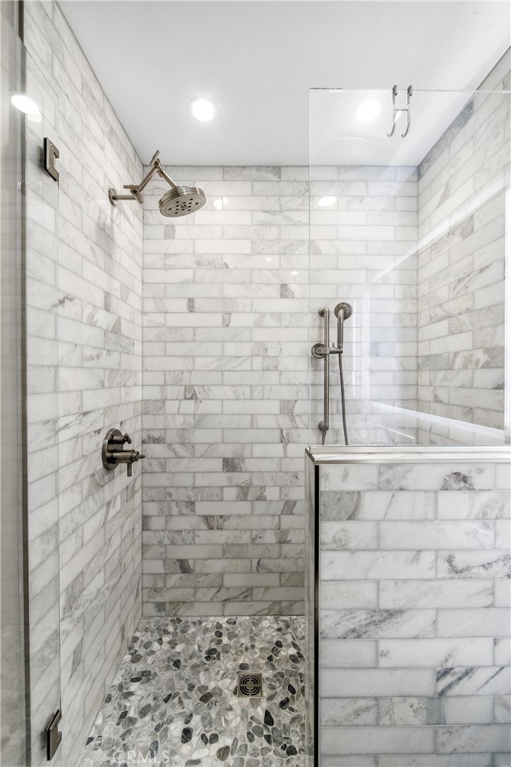 5522 Mossvale Circle Huntington Beach, CA 92649 - Photo 50 of 61 Bright designer bath with marble shower, dual heads, stacked stone accents, and elegant vanity.