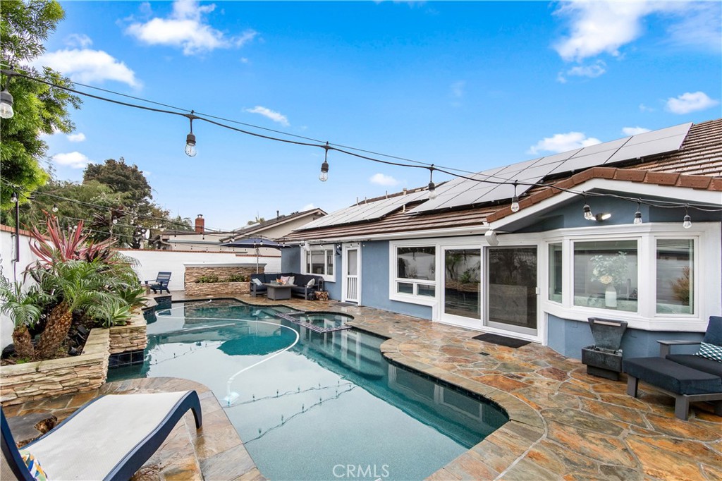 5522 Mossvale Circle Huntington Beach, CA 92649 - Photo 52 of 61 Custom curved pool with central spa, navy tile, stacked stone waterfall, and elegant entry steps.