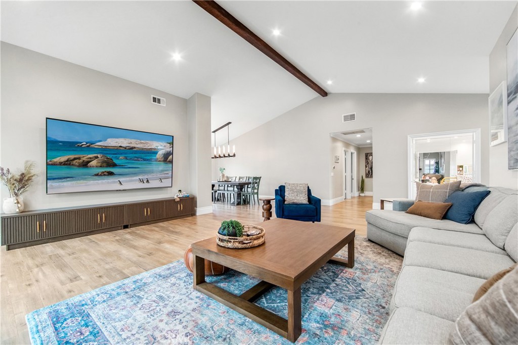 5522 Mossvale Circle Huntington Beach, CA 92649 - Photo 6 of 61 Expansive light-filled living room with vaulted ceilings, exposed beam, marble fireplace, and wall-to-wall French doors.