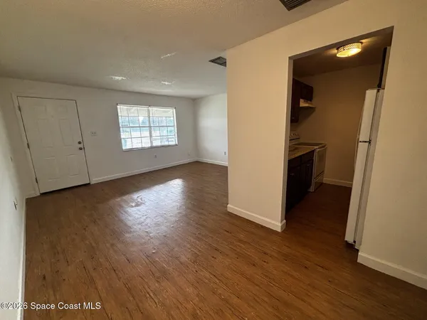 an empty room with wooden floor and a window