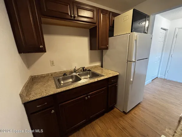a kitchen with a sink refrigerator and microwave