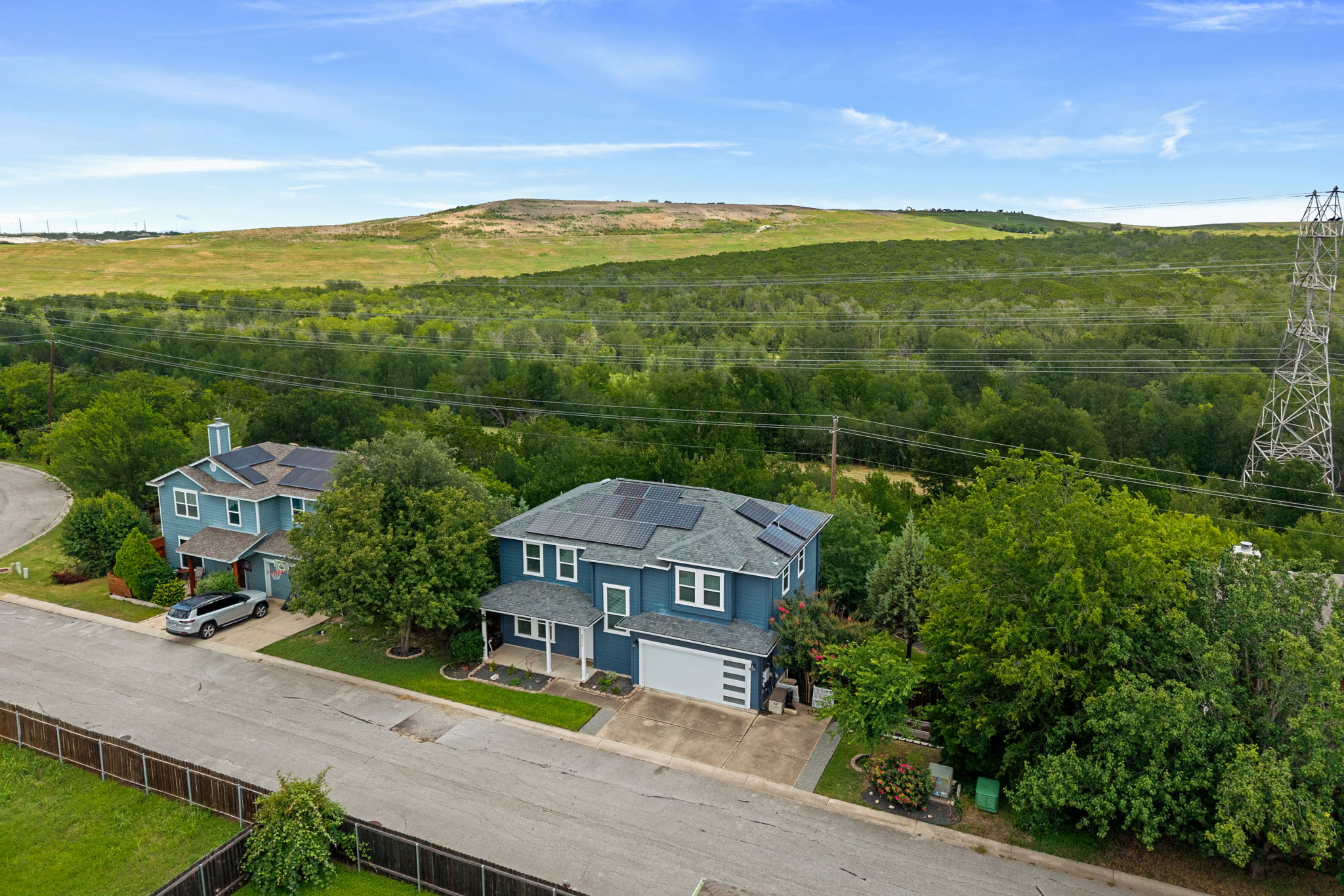8902 Magna Carta Loop, Unit 122 Austin, TX 78754 - Photo 2 of 39 An aerial perspective showcases a vibrant solar powered home nestled in a lush, green landscape.