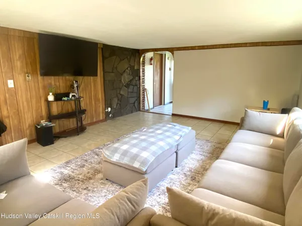 a living room with furniture a flat screen tv and a large window