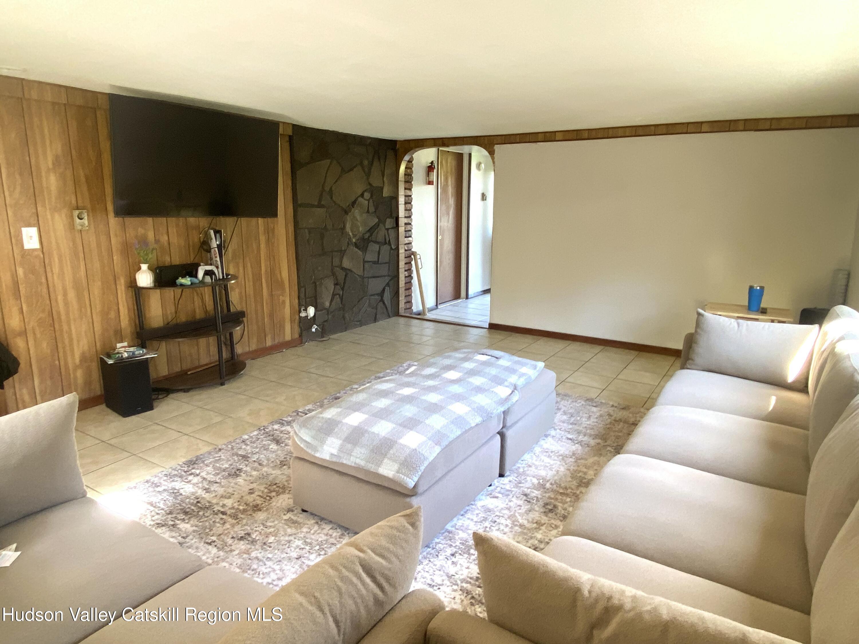 53654 Highway 30 Roxbury, NY 12474 - Photo 7 of 18 a living room with furniture a flat screen tv and a large window