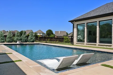 a view of swimming pool with outdoor seating and plants
