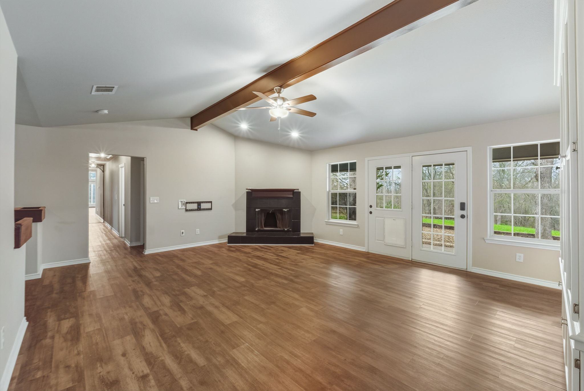 20808 Sandy Brown Lane Webberville, TX 78621 - Photo 9 of 40 Large Living Room Equipped with a Ceiling Fan and a Cozy Fireplace