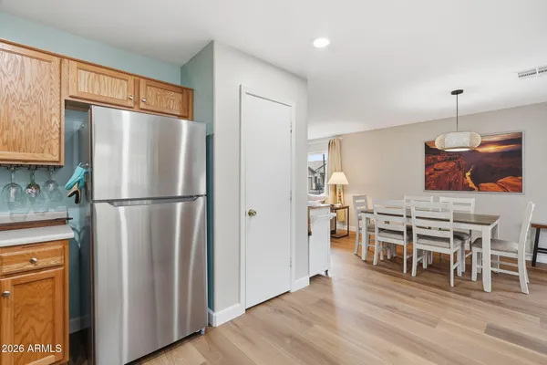 a kitchen with stainless steel appliances wooden floor and dining table