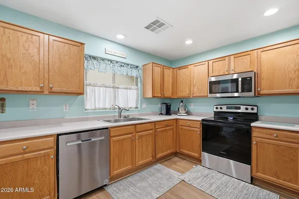 a kitchen with stainless steel appliances granite countertop a stove sink microwave and window