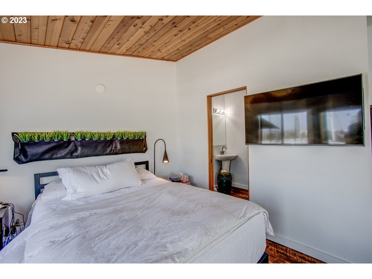 173 Northeast Bridgeton Road, Unit 24 Portland, OR 97211 - Photo 31 of 36 a bedroom with a bed and a television