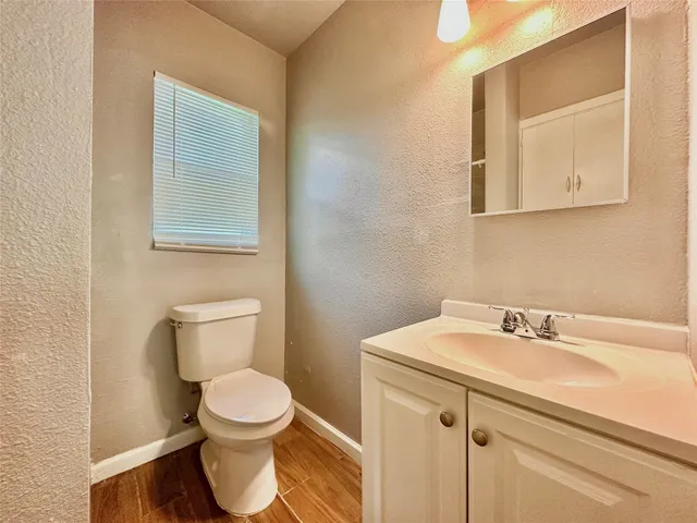 a bathroom with a toilet a sink and mirror