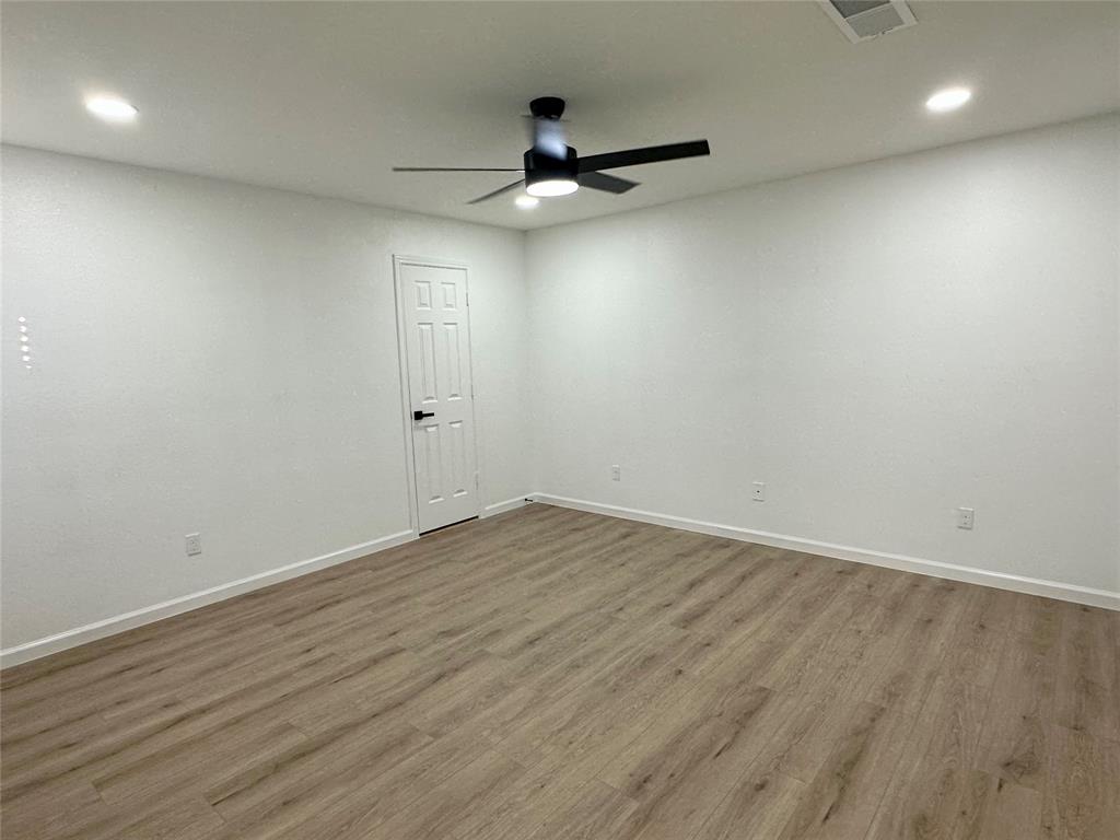 601 Short Street McKinney, TX 75069 - Photo 13 of 28 an empty room with wooden floor and windows