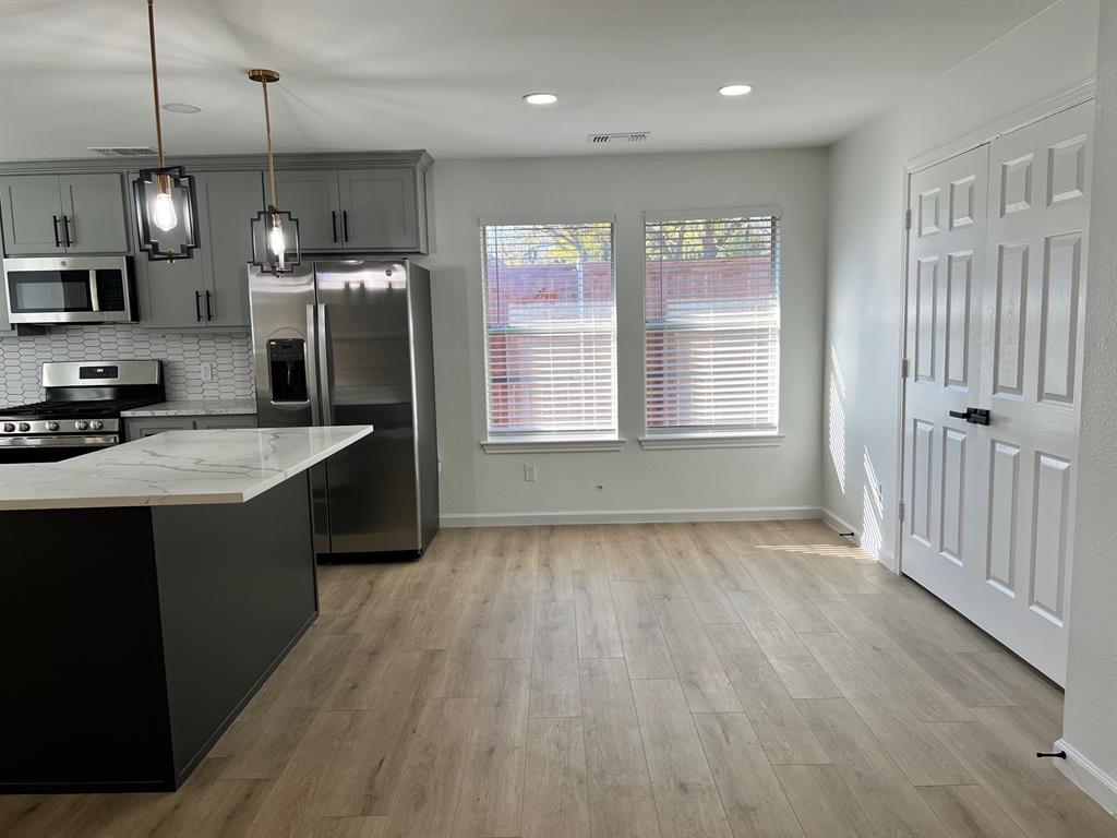 601 Short Street McKinney, TX 75069 - Photo 25 of 28 a kitchen with stainless steel appliances granite countertop a sink a stove and a wooden floors