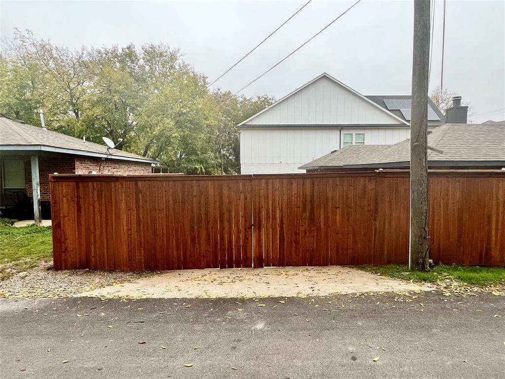 601 Short Street McKinney, TX 75069 - Photo 7 of 28 a wooden house with a wooden fence next to a road
