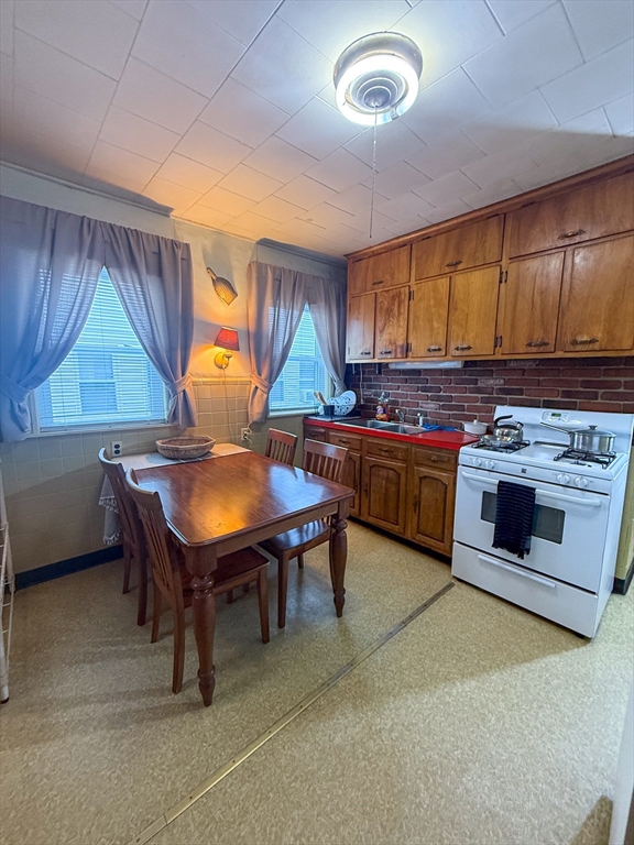 25 Clark Street Everett, MA 02149 - Photo 16 of 40 a kitchen with a stove a sink and a refrigerator