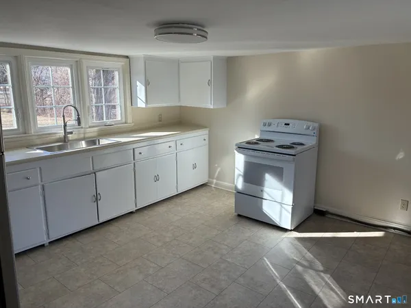 a kitchen with a sink a refrigerator and cabinets