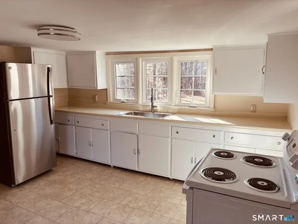 a view of kitchen with refrigerator cabinet and door