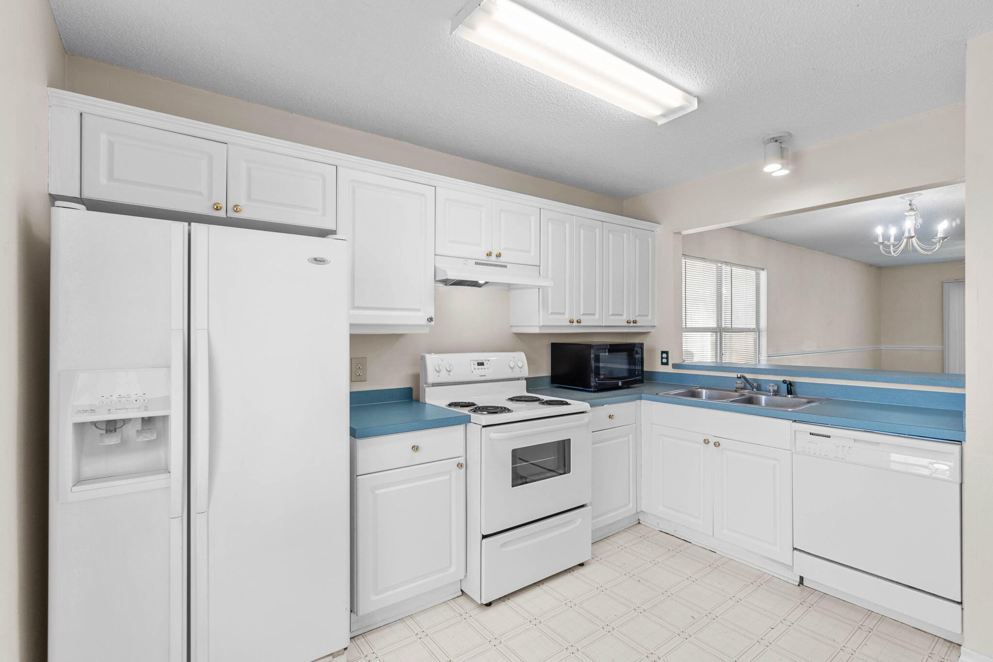 7612 Chablis Circle Navarre, FL 32566 - Photo 11 of 28 a kitchen with white cabinets and white appliances