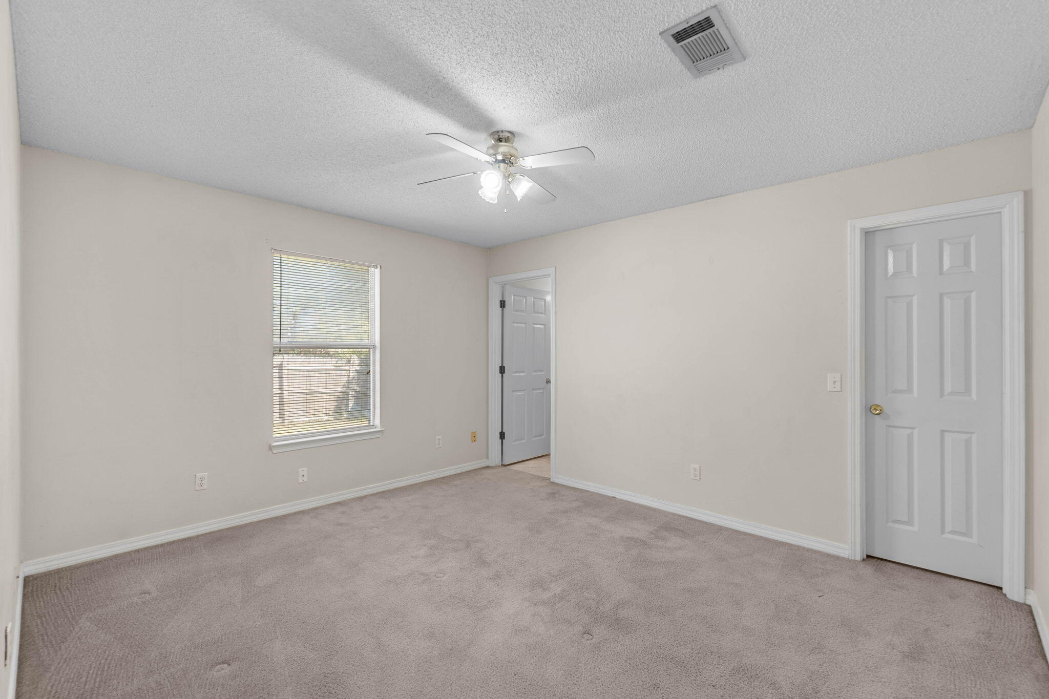 7612 Chablis Circle Navarre, FL 32566 - Photo 22 of 28 an empty room with chandelier fan and windows