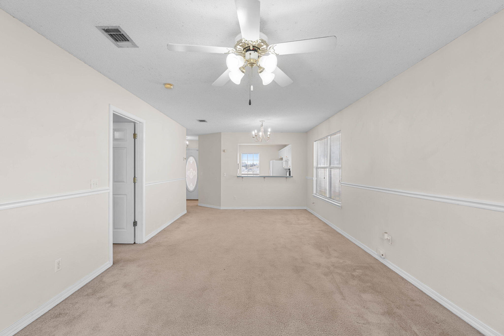 7612 Chablis Circle Navarre, FL 32566 - Photo 9 of 28 an empty room with chandelier and windows