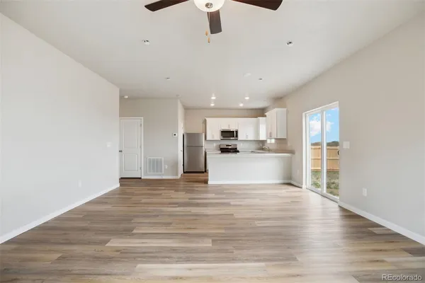 a view of kitchen with granite countertop cabinets and refrigerator