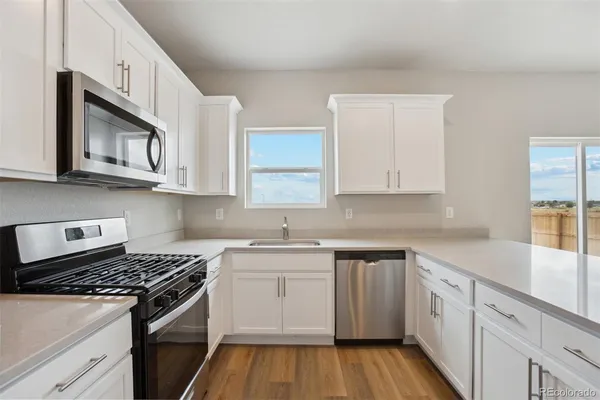 a kitchen with white cabinets and sink