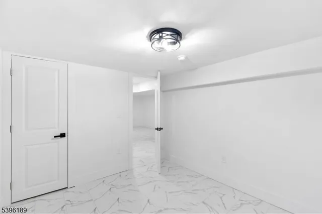 a view of a grey house with a small yard and large tree