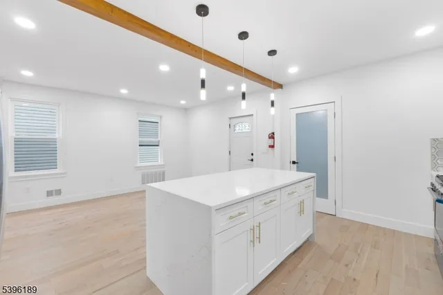 a large white kitchen with white cabinets and stainless steel appliances